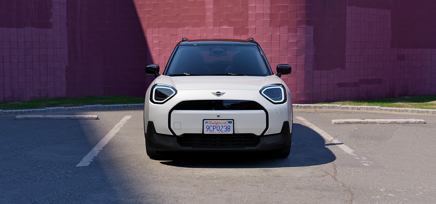 Vue avant du MINI Aceman Electric Nanuq White avec toit blanc stationné.