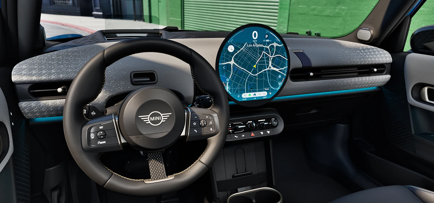 Vue de l'intérieur de la MINI Cooper 5 portes mettant l'accent sur le volant, le tableau de bord et l'unité d'interaction.