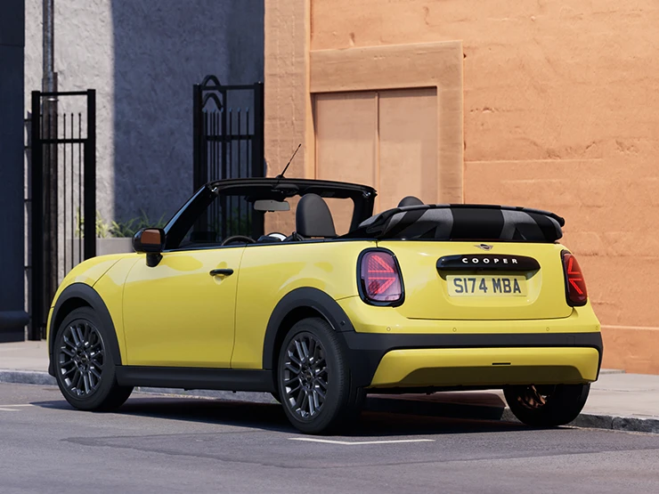 Vue arrière gauche de la MINI Cooper Cabrio Sunnyside Yellow en stationnement.