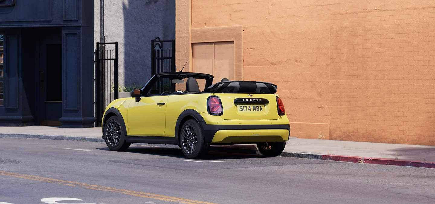Vue arrière gauche de la MINI Cooper Cabrio Sunnyside Yellow en stationnement.