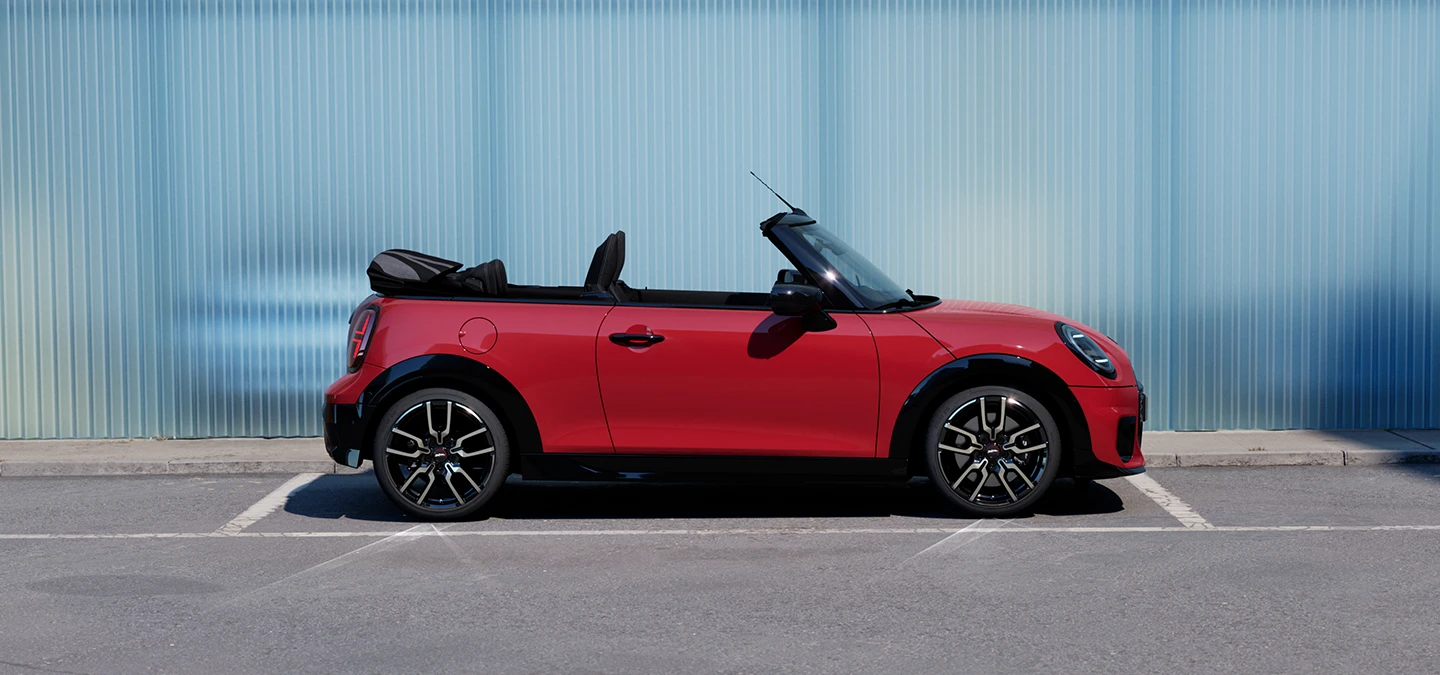 Vue latérale de la MINI Cooper Cabrio Chili Red en ville.
