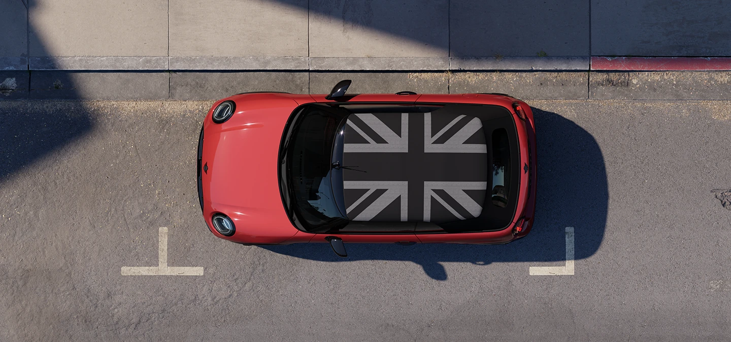 Vue du dessus de la MINI Cooper Cabrio Chili Red avec toit MINI Yours stationnée en ville.